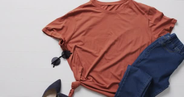 Video Von Orangefarbenem Shirt Jeanshose Sonnenbrille Und Kopierraum Auf Weißem — Stockvideo