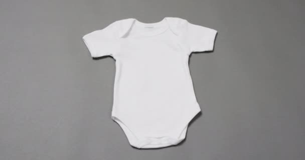 Beyaz Bebeğin Videosu Gri Arka Planda Çoğalıyor Bebek Giysi Kumaş — Stok video