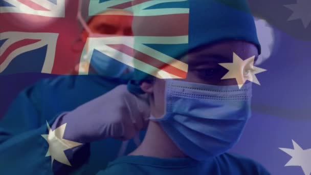 Animação Bandeira Austrália Acenando Sobre Cirurgião Caucasiano Ajudando Cirurgião Feminino — Vídeo de Stock