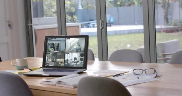 4つのホームセキュリティカメラビューを表示するダイニングテーブル上のラップトップ スローモーション テクノロジー セキュリティ 家庭生活 コミュニケーション — ストック動画