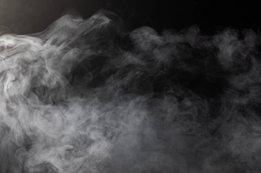 Siyah arkaplanda fotokopi alanı olan beyaz duman bulutları. Cadılar Bayramı, renk, hareket ve duman konsepti.