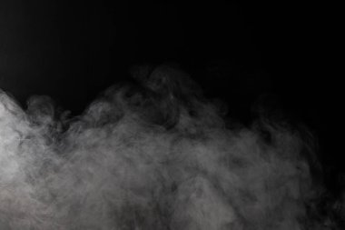 Siyah arkaplanda fotokopi alanı olan beyaz duman bulutları. Cadılar Bayramı, renk, hareket ve duman konsepti.
