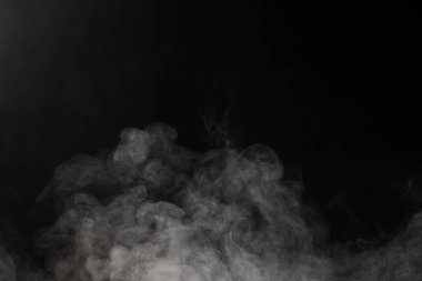 Siyah arkaplanda fotokopi alanı olan beyaz duman bulutları. Cadılar Bayramı, renk, hareket ve duman konsepti.