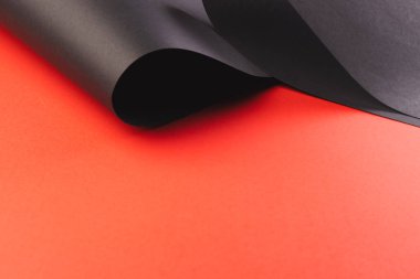 Kırmızı arka planda kopya alanı olan siyah kağıt parçalarını kapat. Kağıt, yazı, doku ve malzeme kavramı.