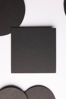 Karenin dikey görüntüsü ve beyaz zemin üzerinde kopyalama alanı olan siyah kağıt çemberleri. Kağıt, yazı, doku ve malzeme kavramı.