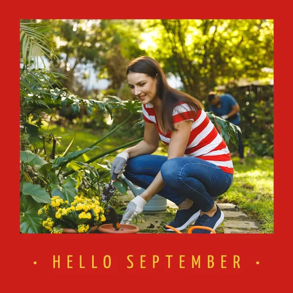 Composite of hello september text over caucasian woman in garden. Hello september, fall, autumn and nature concept digitally generated image.