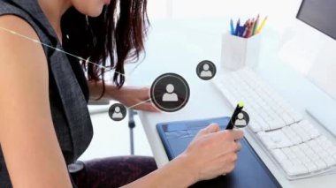 Bağlı ikonlar ve klavyeye yazı yazan ve grafik tabletine resim çizen Asyalı kadın animasyonu. Dijital bileşik, çoklu pozlama, iletişim, iş dünyası, yaratıcı, ofis ve teknoloji.