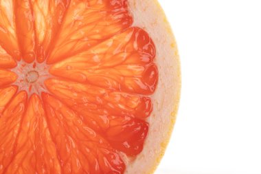 Dilimlenmiş kırmızı greyfurt mikro yakın plan ve beyaz arkaplanda kopyalama alanı. Mikro fotoğrafçılık, yemek, doku ve renk kavramı.