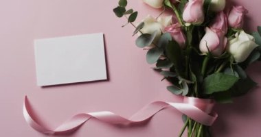 Zarflı beyaz ve pembe güllerin videosu ve pembe arka planda kopyalama alanı. Renk, doğa ve çiçek kavramı.