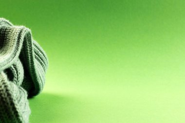 Yeşil arkaplanda fotokopi alanı olan yeşil yün örgü kumaşının mikro görüntüsü. Mikro fotoğrafçılık, kumaş, desen, doku ve renk kavramı.