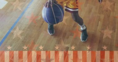 Afrika kökenli Amerikalı basketbolcunun mahkemede top sürmesi üzerine bayrak animasyonu. Dijital kompozit, vatanseverlik, el, bacak, spor, rekabet, uygulama ve oyun konsepti.