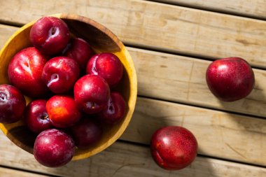 Tahta masanın üstünde, kâse içinde taze şeftali. Değiştirilmemiş, meyve, yiyecek, olgun, kırmızı ve sağlıklı konsept.