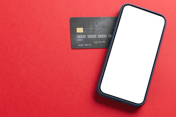 赤い背景に空白のスクリーンとクレジットカードが付いているスマートフォン サイバー月曜日 サイバーショッピング テクノロジー 電子デバイス 通信コンセプト — ストック写真