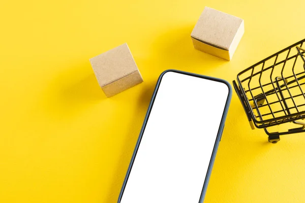 Smartphone Mit Kopierraum Und Trolley Mit Boxen Auf Gelbem Hintergrund — Stockfoto