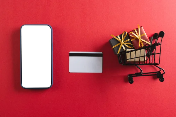 Kreditkarten Smartphone Mit Kopierraum Und Einkaufswagen Mit Geschenken Auf Rotem — Stockfoto