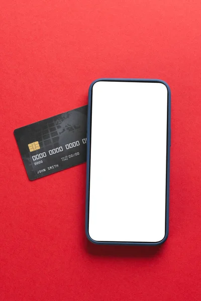 赤い背景に空白の画面とクレジットカードを備えたスマートフォンの垂直画像 サイバー月曜日 サイバーショッピング テクノロジー 電子デバイス 通信コンセプト — ストック写真
