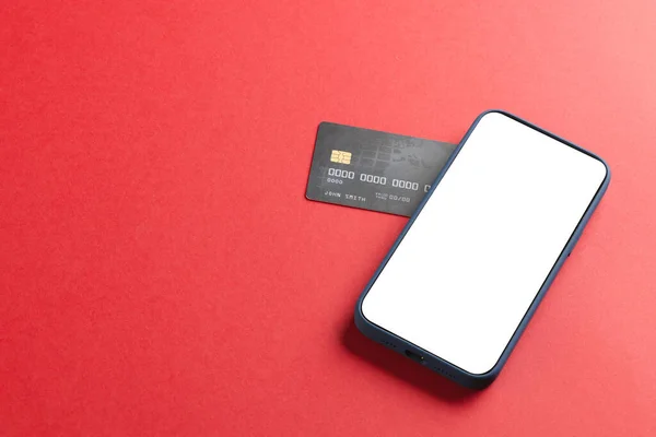 赤い背景に空白のスクリーンとクレジットカードが付いているスマートフォン サイバー月曜日 サイバーショッピング テクノロジー 電子デバイス 通信コンセプト — ストック写真