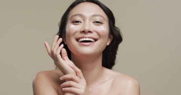 Glückliche Asiatin Mit Dunklen Haaren Die Ihr Gesicht Auf Beigem — Stockvideo