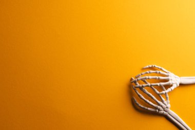 Sarı zemin üzerinde kopya alanı olan plastik iskelet eller. Sonbahar, sonbahar, cadılar bayramı, gelenek ve kutlama konsepti.
