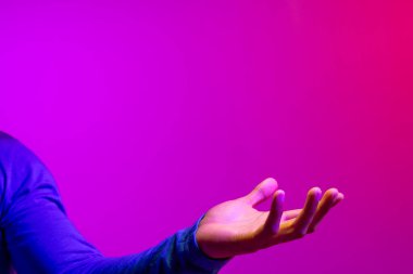 Kafkasyalı iş adamının eli. Fotokopi alanı, neon pembesi ve mor arka plan üzerine. Teknoloji, dijital ağlar, küresel bağlantılar ve iletişim metaevreleri.