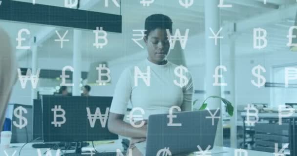 Animação Símbolos Monetários Sobre Mulher Afro Americana Sentada Mesa Usando — Vídeo de Stock
