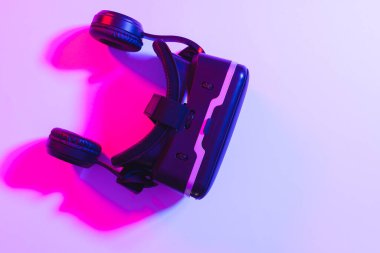 Neon arkaplanda kopyalama alanı olan vr kulaklığının birleşimi. Video oyunu ve dijital bağlantılar konsepti dijital olarak oluşturulmuş görüntü.