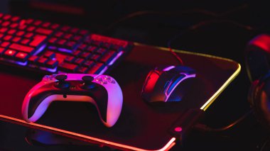 Bilgisayar bileşimi, neon arkaplanda kopya alanı olan video oyunu aksesuarları. Video oyunu ve dijital bağlantılar konsepti dijital olarak oluşturulmuş görüntü.