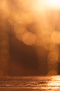 Sarı Bokeh 'in dikey görüntüsü fotokopi alanı ile bulanık ışıklar ve koyu arkaplanda ahşap yüzey. Işık, renk ve şekil kavramı dijital olarak oluşturuldu.