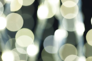 Koyu arkaplanda kopyalama alanı olan çok sayıda beyaz bokeh ışığı. Işık, renk ve şekil kavramı dijital olarak oluşturuldu.