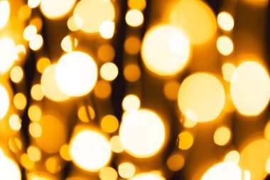 Koyu arkaplanda kopyalama alanı olan çoklu sarı bokeh ışıkları. Işık, renk ve şekil kavramı dijital olarak oluşturuldu.