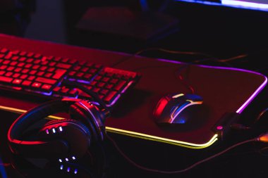 Bilgisayar klavyesinin bilgisayar oyunu aksesuarları ile neon arkaplanda kopyalama alanı ile birleşimi. Video oyunu ve dijital bağlantılar konsepti dijital olarak oluşturulmuş görüntü.