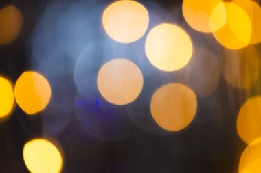 Koyu arkaplanda kopyalama alanı olan çoklu sarı bokeh ışıkları. Işık, renk ve şekil kavramı dijital olarak oluşturuldu.