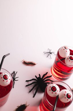 Cadılar Bayramı dekorasyonlarının dikey görüntüsü ve beyaz arka planda fotokopi alanı olan yemekler. Sonbahar, sonbahar, cadılar bayramı, gelenek ve kutlama konsepti.