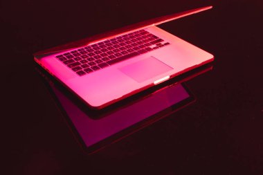 Parlak ekranlı dizüstü bilgisayarın birleşimi ve neon arka planda kopyalama alanı. Video oyunu ve dijital bağlantılar konsepti dijital olarak oluşturulmuş görüntü.