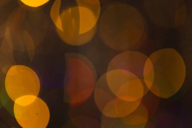 Koyu arkaplanda kopyalama alanı olan çoklu sarı bokeh ışıkları. Işık, renk ve şekil kavramı dijital olarak oluşturuldu.