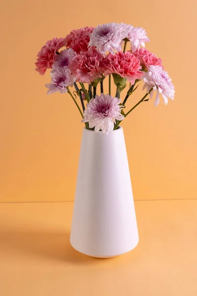 Вертикальное Изображение Розовых Цветов Белой Вазе Копировать Пространство Оранжевом Фоне — стоковое фото
