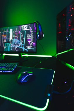 Bilgisayarın dikey görüntüsü, neon arkaplanda kopya alanı olan video oyunu aksesuarları. Video oyunu ve dijital bağlantılar konsepti dijital olarak oluşturulmuş görüntü.