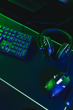 Bilgisayarın dikey görüntüsü, neon arkaplanda kopya alanı olan video oyunu aksesuarları. Video oyunu ve dijital bağlantılar konsepti dijital olarak oluşturulmuş görüntü.