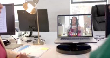 Ekranda Afro-Amerikan iş kadınıyla video bağlantısı olan bir laptop. Çevrimiçi bağlantılar, iş ve ağ oluşturma kavramı.