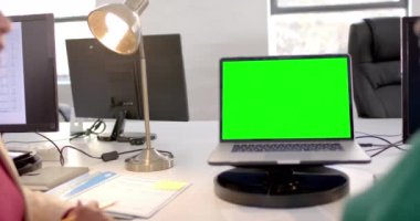 Ofisteki yeşil ekranlı bir dizüstü bilgisayar. Çevrimiçi bağlantılar, iş ve ağ oluşturma kavramı.