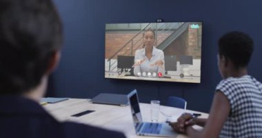 Afrika kökenli Amerikalı bayan meslektaşımla TV ekranında görüntülü görüşme yapan çeşitli iş adamları. Çevrimiçi bağlantılar, iş ve ağ oluşturma kavramı.