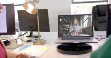 Kafkasyalı iş kadınıyla ekranda video bağlantısı olan bir laptop. Çevrimiçi bağlantılar, iş ve ağ oluşturma kavramı.