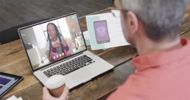 Kafkasyalı iş adamı, ekranda Afro-Amerikan bayan meslektaşıyla görüntülü konuşma yapıyor. Çevrimiçi bağlantılar, iş ve ağ oluşturma kavramı.
