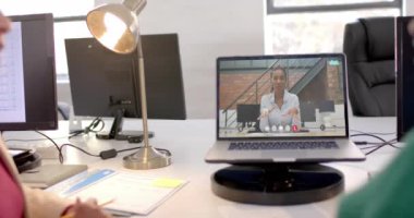 Ekranda Afro-Amerikan iş kadınıyla video bağlantısı olan bir laptop. Çevrimiçi bağlantılar, iş ve ağ oluşturma kavramı.