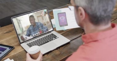 Kafkasyalı iş adamı, ekranda Afrikalı Amerikalı bir erkek meslektaşla görüntülü konuşma yapıyor. Çevrimiçi bağlantılar, iş ve ağ oluşturma kavramı.