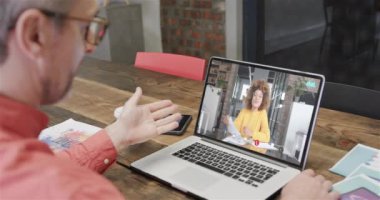 Kafkasyalı iş adamı, ekranda Afro-Amerikan bayan meslektaşıyla görüntülü konuşma yapıyor. Çevrimiçi bağlantılar, iş ve ağ oluşturma kavramı.