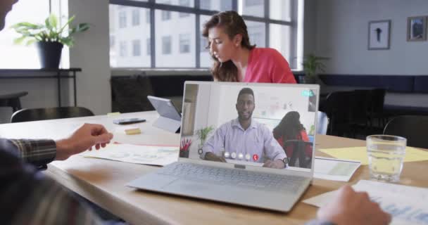 アフリカ系アメリカ人男性同僚とのラップトップビデオ通話に関するコーカサス人のビジネスマン オンライン接続 ビジネス ネットワーキングコンセプト — ストック動画