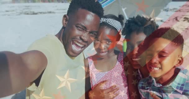 Animacja Flagi Ameryki Nad Afrykańskim Amerykaninem Robiącym Selfie Rodziną Plaży — Wideo stockowe