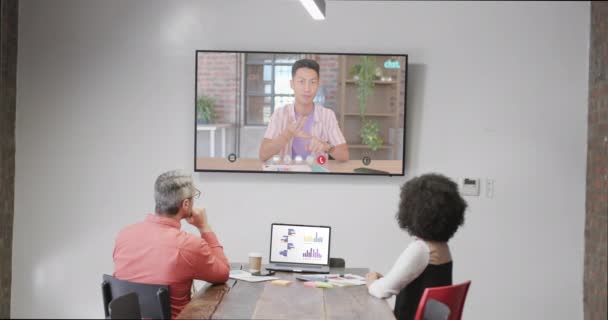 テレビのスクリーンで白人男性同僚とのビデオ通話で多様なビジネスマン オンライン接続 ビジネス ネットワーキングコンセプト — ストック動画
