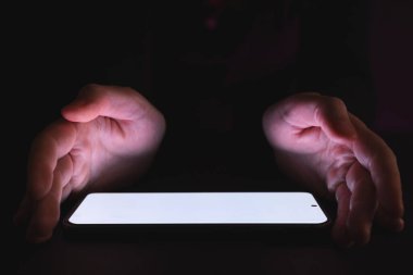 Kopyalama alanı, parlak ışık ekranı ve siyah arka planda beyaz elleri olan tablet. Video oyunu ve dijital bağlantılar konsepti dijital olarak oluşturulmuş görüntü.